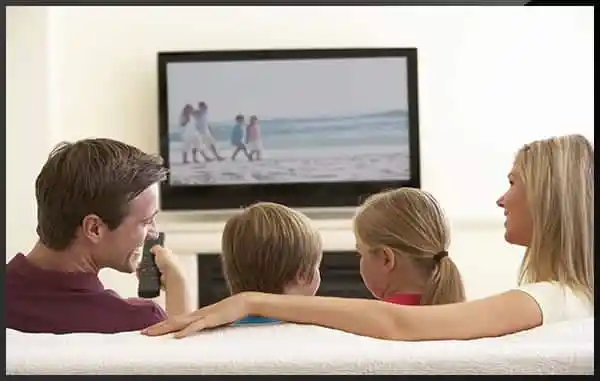 Family watching live TV and streaming entertainment through IPTV service on a Smart TV.